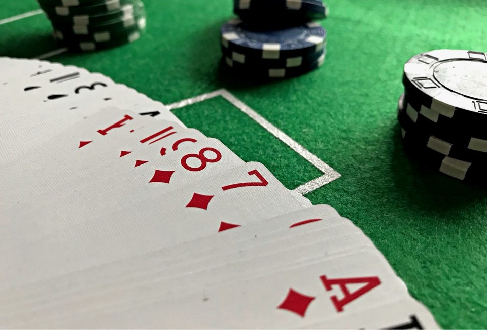 Playing cards and chips on green baize